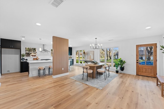 dining area featuring light wood finished floors, baseboards, visible vents, a chandelier, and recessed lighting