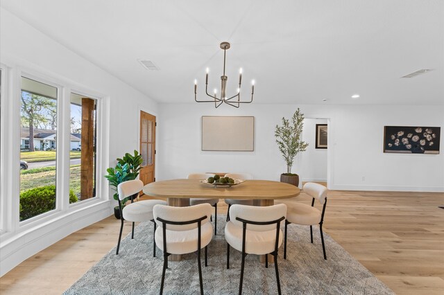 dining room featuring a chandelier, light wood-type flooring, and visible vents