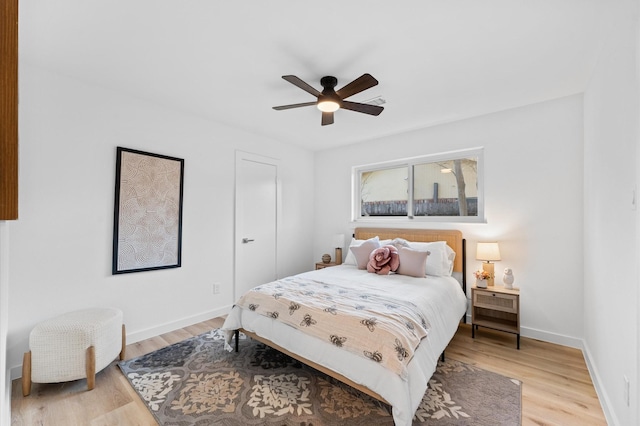 bedroom with light wood-style flooring, baseboards, and ceiling fan