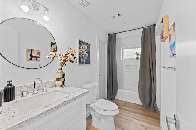 bathroom featuring toilet, a shower with shower curtain, wood finished floors, and visible vents