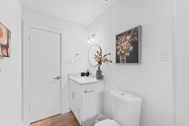 bathroom featuring vanity, toilet, and wood finished floors