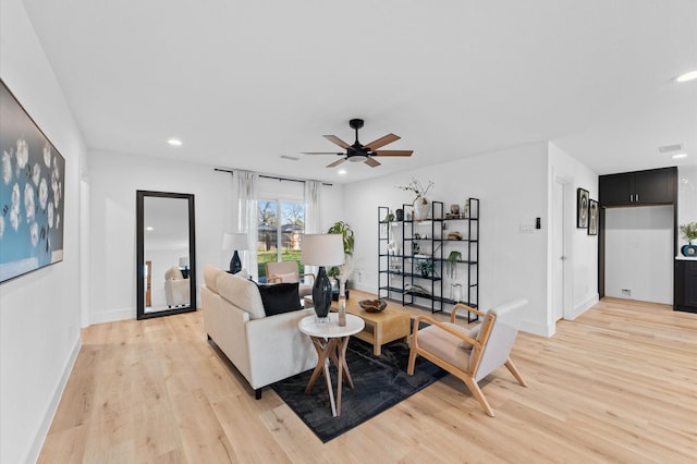 living room with a ceiling fan, recessed lighting, light wood-style flooring, and baseboards