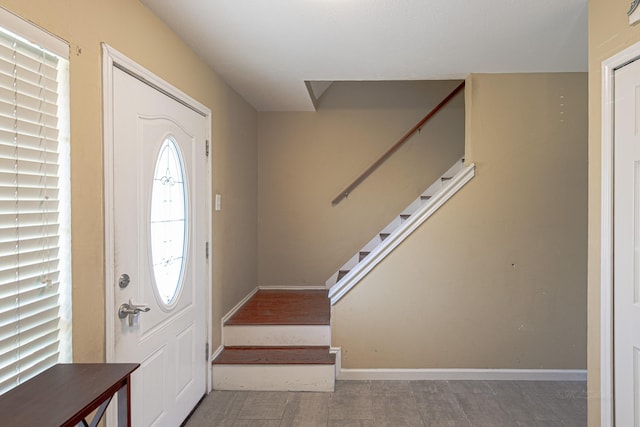 foyer with stairs and baseboards