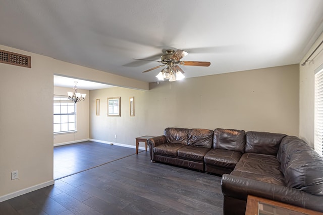 living area with visible vents, baseboards, dark wood-type flooring, and ceiling fan with notable chandelier