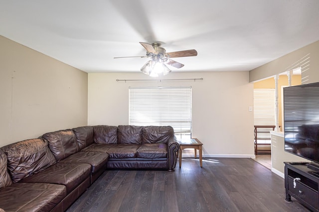 living area featuring baseboards, dark wood-style flooring, and ceiling fan