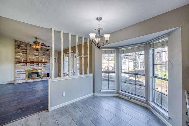 unfurnished dining area with plenty of natural light, wood finished floors, and a fireplace