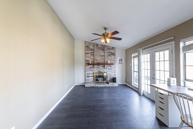 unfurnished living room with baseboards, a fireplace, vaulted ceiling, dark wood-type flooring, and french doors