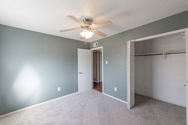 unfurnished bedroom featuring visible vents, carpet floors, ceiling fan, a closet, and a textured ceiling