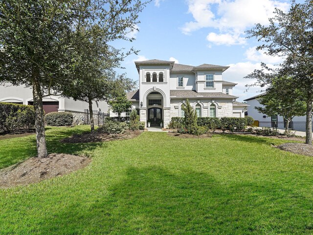136 Thunder Valley Dr, Tomball, TX 77375 - mediterranean / spanish-style house featuring an attached garage, stucco siding, fence, and a front lawn