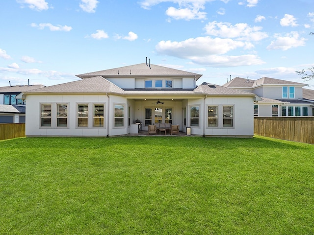 rear view of house featuring a lawn, an outdoor hangout area, a ceiling fan, and a fenced backyard