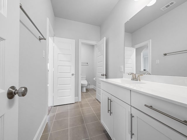 bathroom featuring visible vents, toilet, tile patterned flooring, baseboards, and vanity