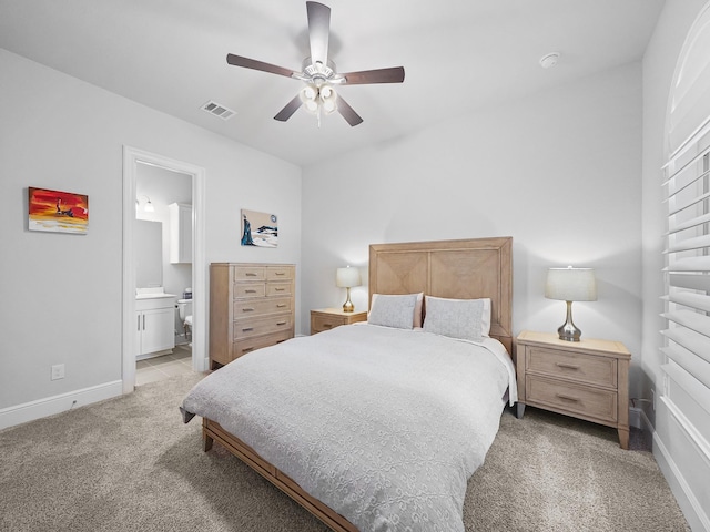 bedroom with visible vents, baseboards, ensuite bath, ceiling fan, and light colored carpet