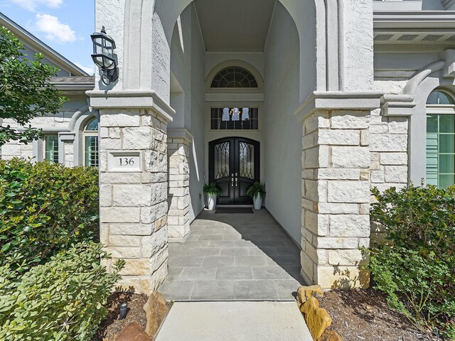 136 Thunder Valley Dr, Tomball, TX 77375 - doorway to property featuring french doors, stone siding, and stucco siding