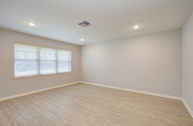 spare room with recessed lighting, light wood-type flooring, visible vents, and baseboards