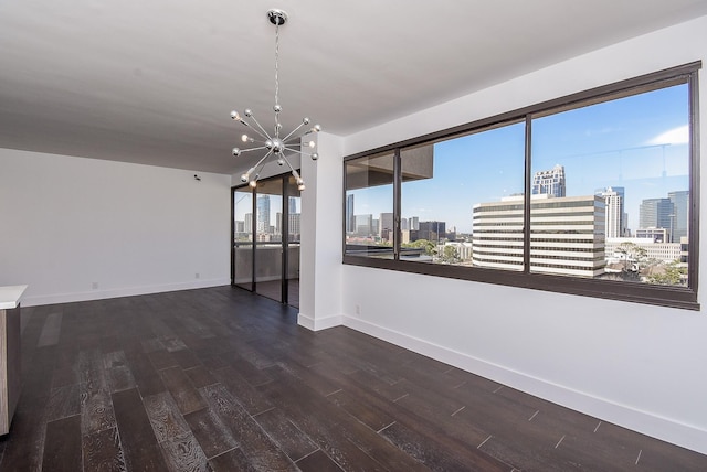 unfurnished dining area with a view of city, a chandelier, wood finished floors, and baseboards