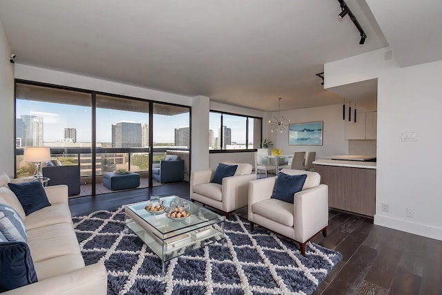 living room with dark wood-style floors, baseboards, a city view, and an inviting chandelier