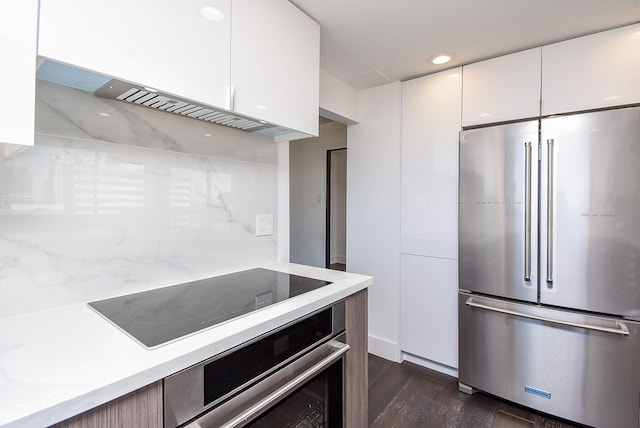 kitchen with dark wood-type flooring, appliances with stainless steel finishes, white cabinets, and light countertops