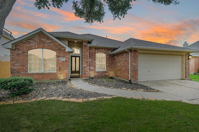 ranch-style home featuring brick siding, a shingled roof, a garage, driveway, and a front lawn