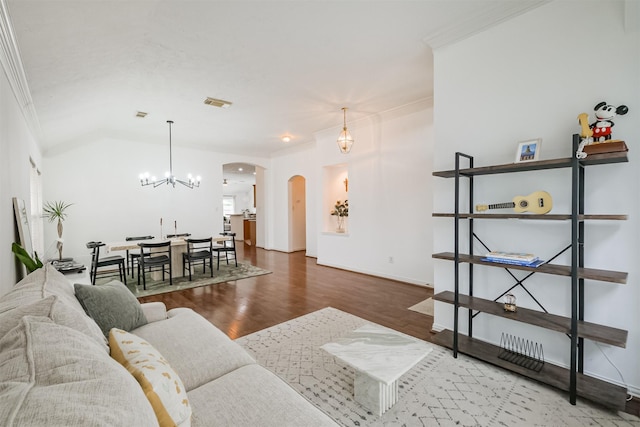 living area with baseboards, visible vents, arched walkways, wood finished floors, and vaulted ceiling