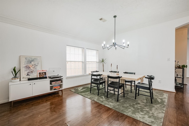 dining space featuring arched walkways, dark wood-style flooring, a notable chandelier, ornamental molding, and baseboards