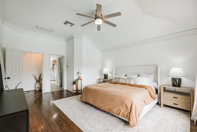 bedroom featuring visible vents, lofted ceiling, ensuite bath, wood-type flooring, and ornamental molding