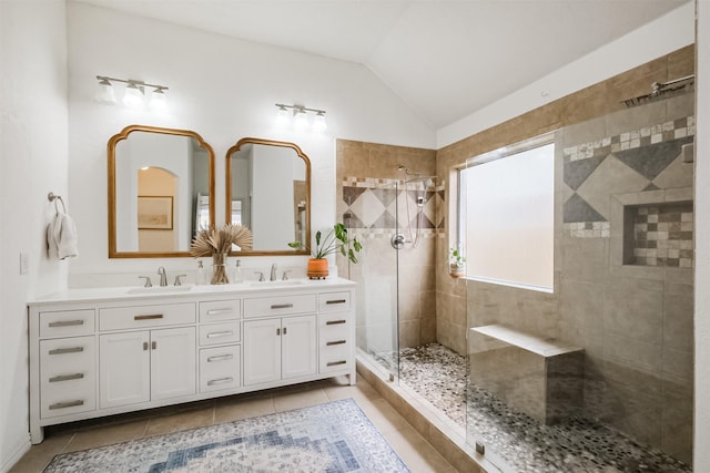 full bath featuring vaulted ceiling, tiled shower, a sink, and tile patterned floors