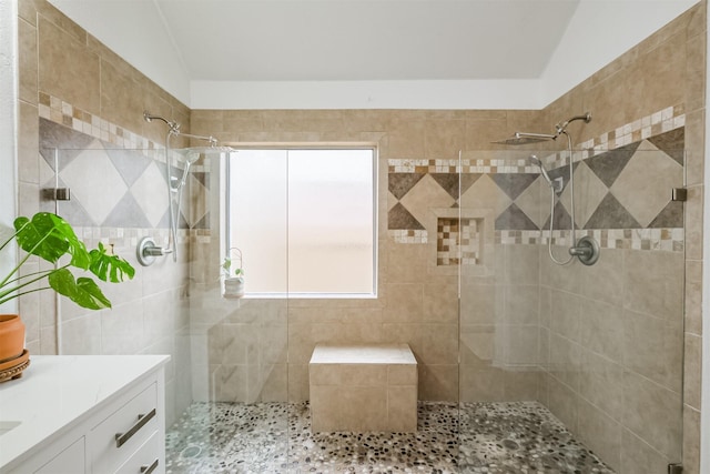 full bathroom with tiled shower and vanity