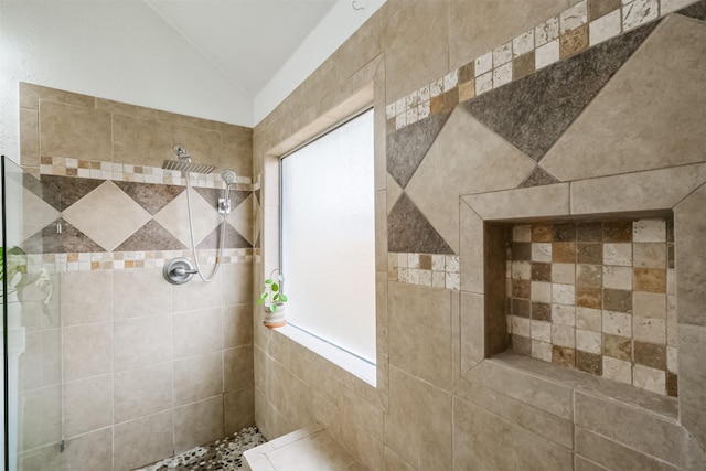 full bath featuring vaulted ceiling and tiled shower