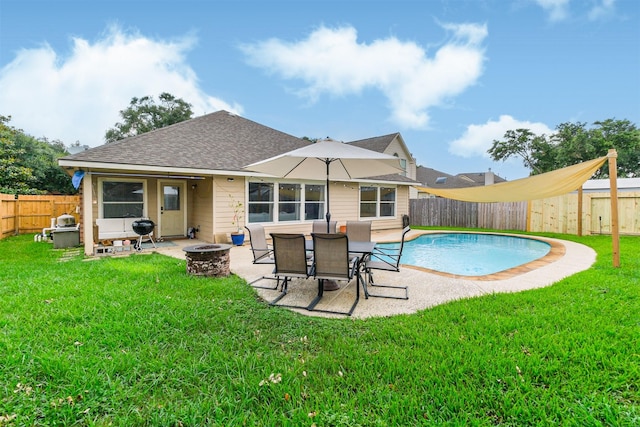 back of property featuring a fire pit, a yard, a patio, and a fenced backyard