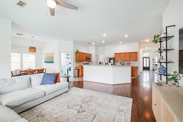 living area featuring arched walkways, ceiling fan, recessed lighting, visible vents, and dark wood-style floors