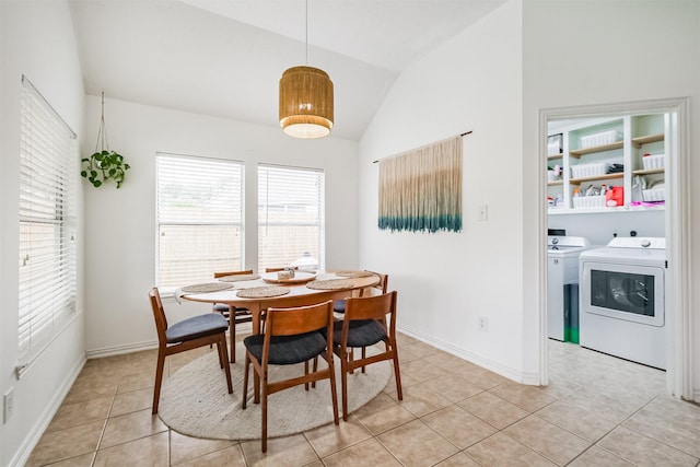 dining area with light tile patterned floors, baseboards, vaulted ceiling, and independent washer and dryer