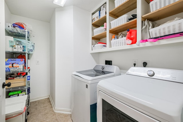 clothes washing area featuring laundry area, light tile patterned floors, baseboards, and separate washer and dryer