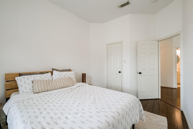 bedroom with dark wood-style floors and visible vents