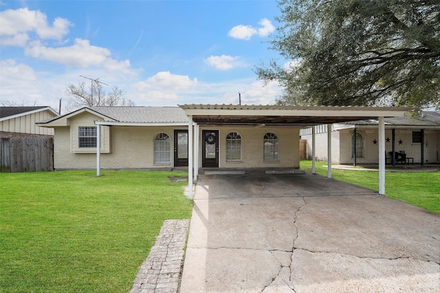 ranch-style home with brick siding, concrete driveway, a front yard, fence, and a carport