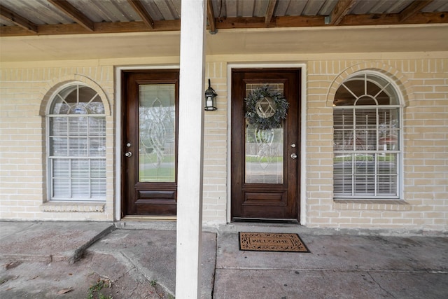 view of exterior entry with brick siding