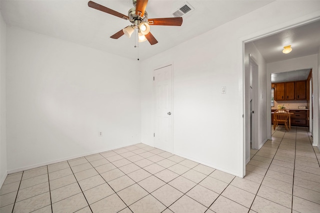 unfurnished room with visible vents, ceiling fan, baseboards, and light tile patterned flooring