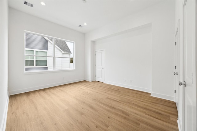 unfurnished room featuring recessed lighting, light wood-type flooring, visible vents, and baseboards