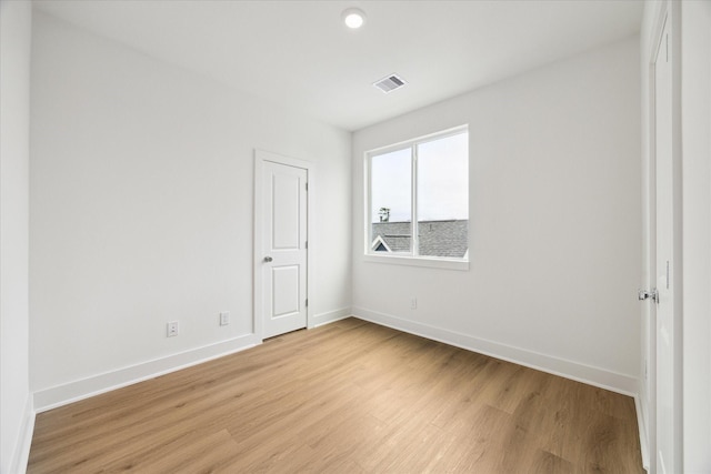 unfurnished room with light wood-style floors, baseboards, and visible vents