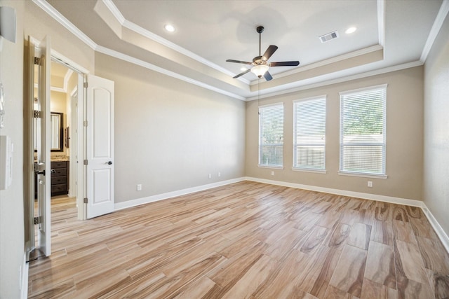 unfurnished room with visible vents, a raised ceiling, baseboards, ceiling fan, and light wood-style flooring