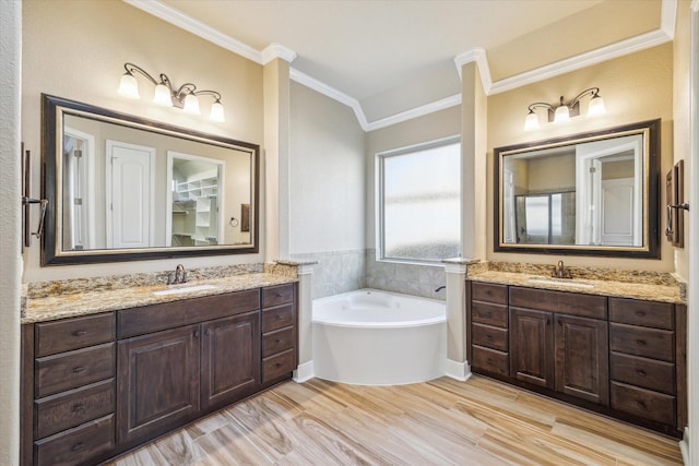 full bathroom with a garden tub, two vanities, a sink, and crown molding