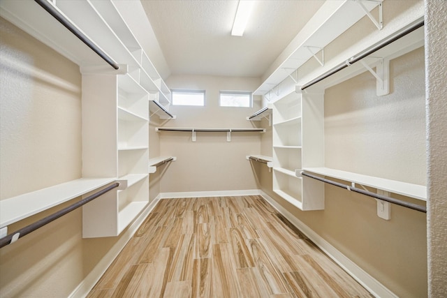 walk in closet with light wood-style floors