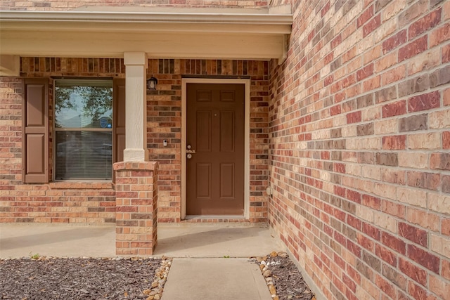 doorway to property with brick siding