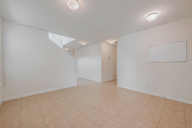 unfurnished room with a textured ceiling and baseboards