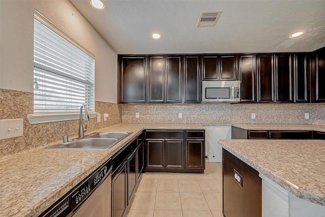 kitchen with light tile patterned floors, visible vents, appliances with stainless steel finishes, a sink, and backsplash