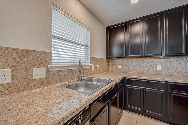 kitchen featuring tasteful backsplash, light countertops, and a sink