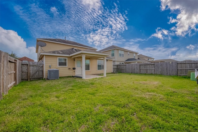 back of property featuring a fenced backyard, a lawn, central AC, and a patio