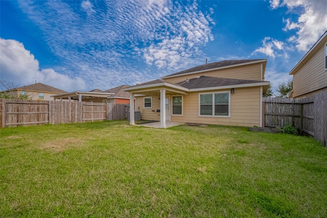 rear view of house with a patio area, a fenced backyard, and a lawn