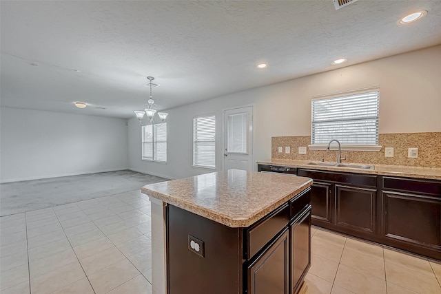 kitchen featuring tasteful backsplash, a sink, light countertops, a wealth of natural light, and light tile patterned flooring