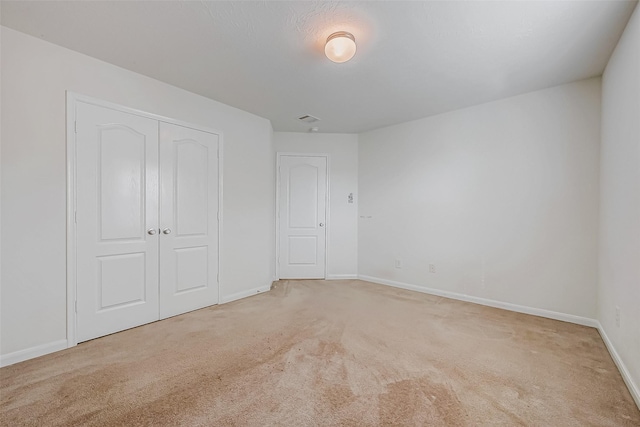 unfurnished bedroom featuring a closet, carpet flooring, and baseboards