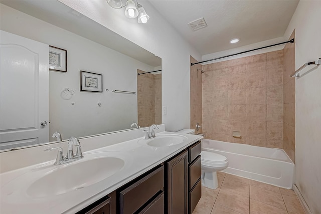 bathroom with toilet, visible vents, a sink, and tile patterned floors